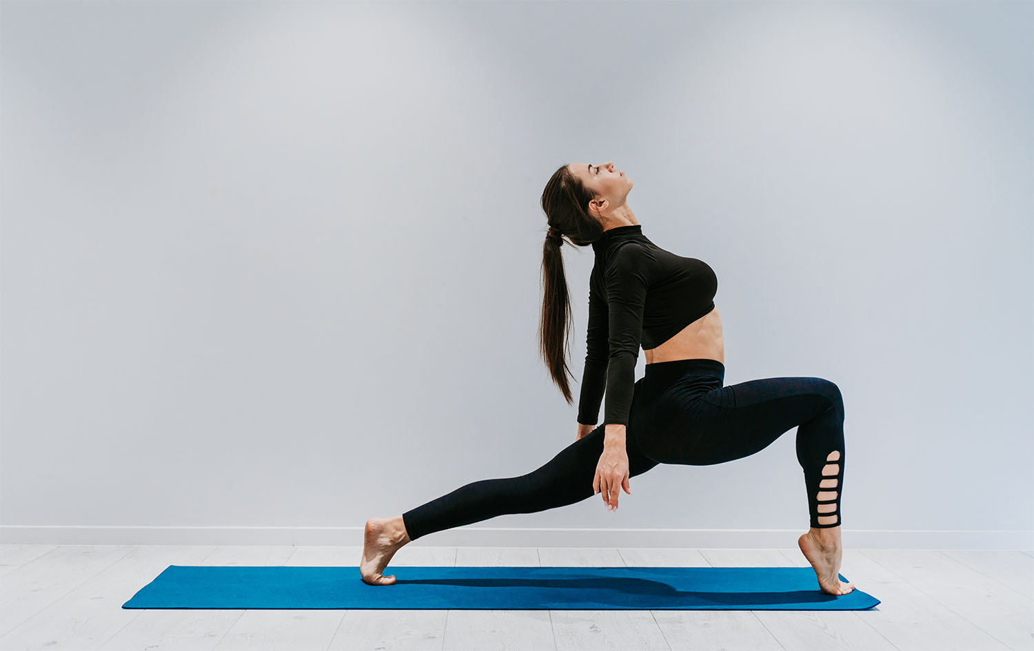 Beautiful girl training in the gym. Russian classic dancer doing stretching and yoga poses
