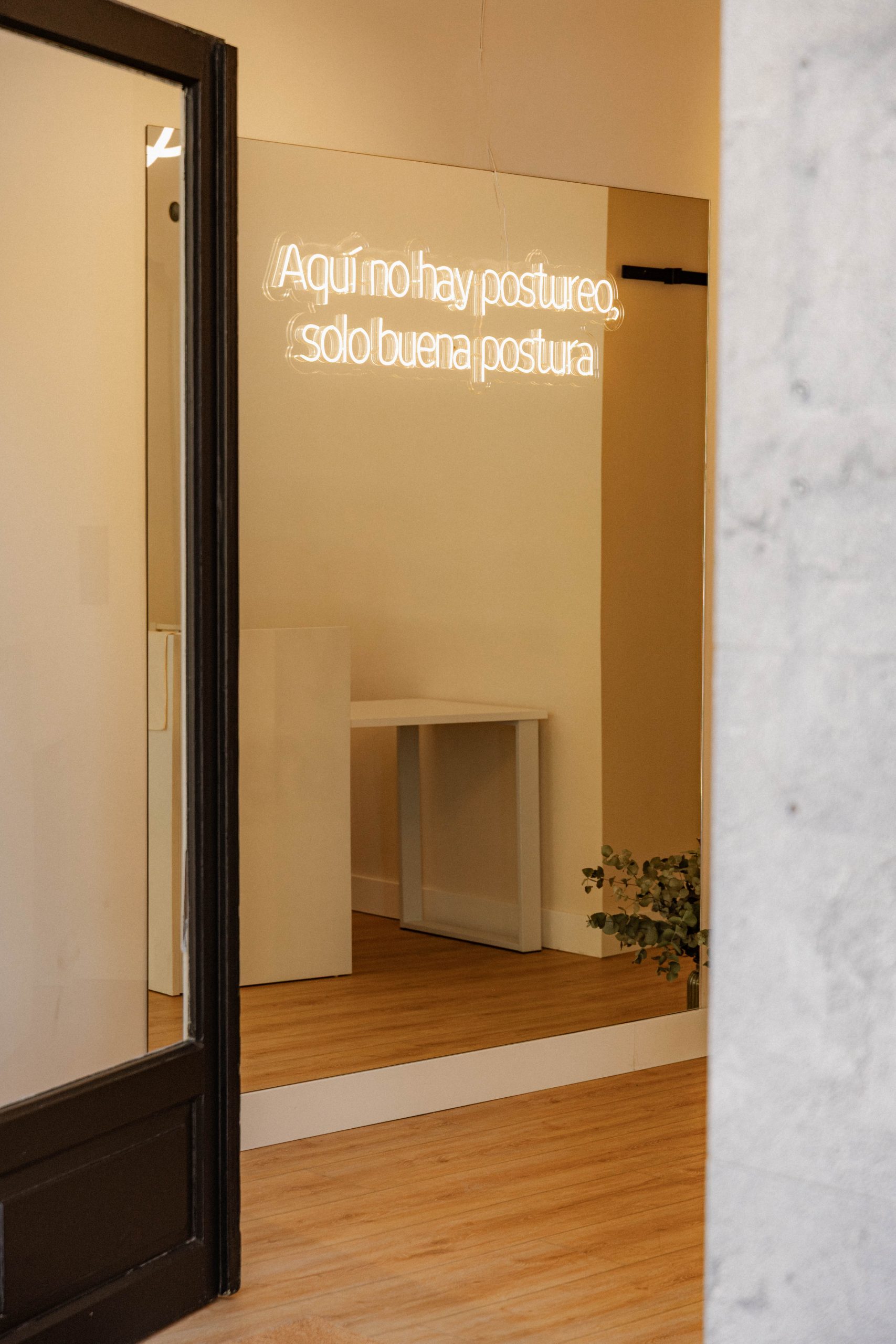 Neon de la recepción que dice "Aquí no hay postureo, solo buena postura"